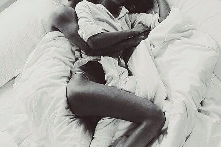 Молодая негритянка со стройными икрами занимается любовью со зрелым мужчиной на кровати