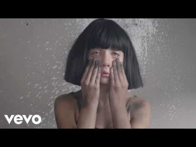 Включи видео сия. Sia - the Greatest актриса. Песня Sia в клипе горит дом. Песня the Greatest Sia.