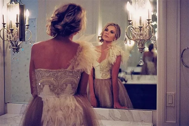 Девушка в платье перед зеркалом